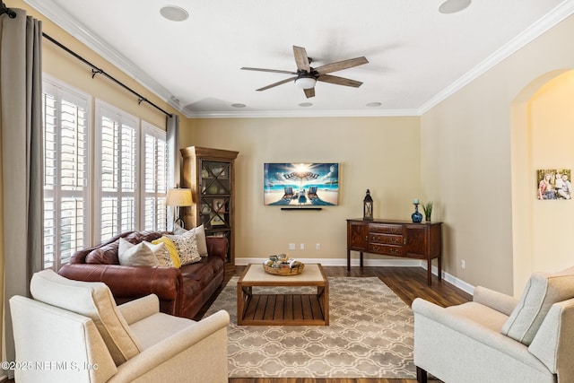 living room with arched walkways, ornamental molding, wood finished floors, and baseboards