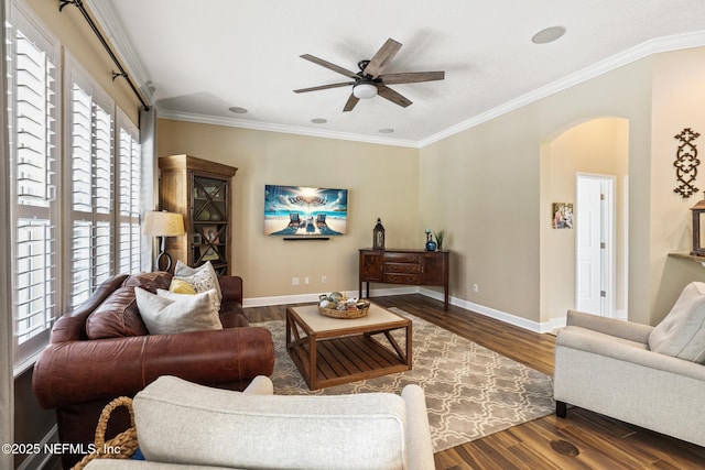 living room featuring arched walkways, crown molding, baseboards, and wood finished floors