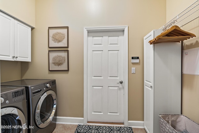 washroom with tile patterned flooring, cabinet space, independent washer and dryer, and baseboards