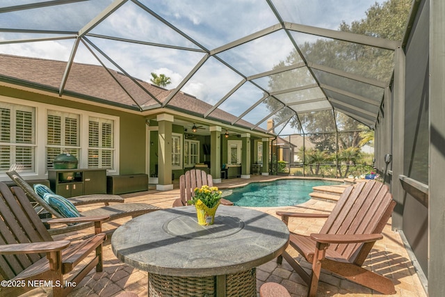 outdoor pool with glass enclosure, ceiling fan, and a patio