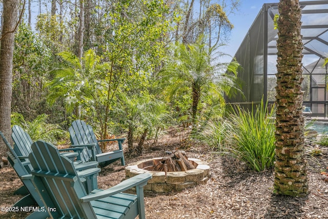 view of yard with glass enclosure and a fire pit