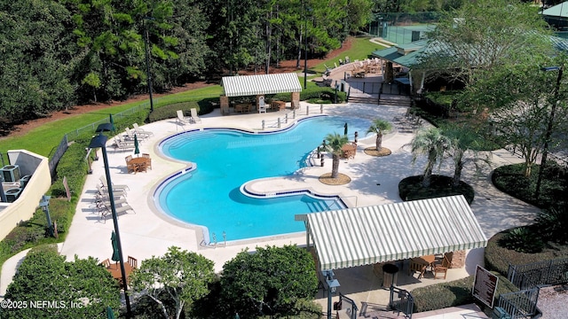 community pool featuring outdoor dry bar, a patio, and fence