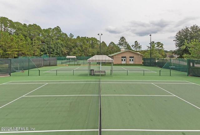 view of tennis court featuring fence