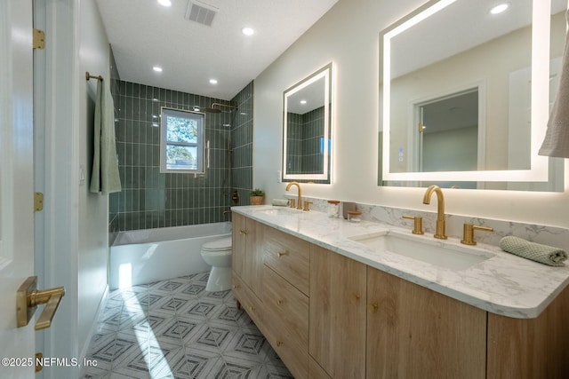 full bath featuring toilet, washtub / shower combination, visible vents, and a sink