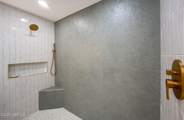 full bath featuring recessed lighting, a tile shower, and a textured ceiling