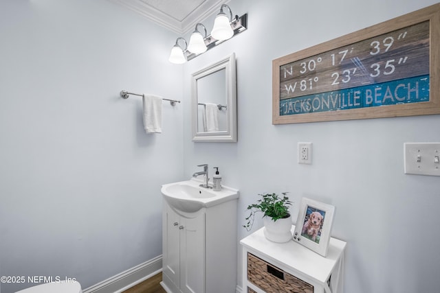 bathroom with ornamental molding, vanity, and baseboards