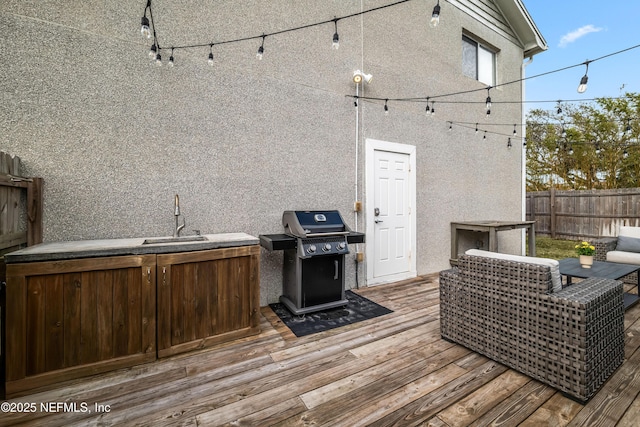 wooden deck featuring grilling area, a sink, and fence