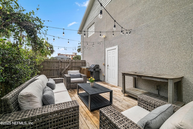 wooden deck featuring a grill, fence, and outdoor lounge area