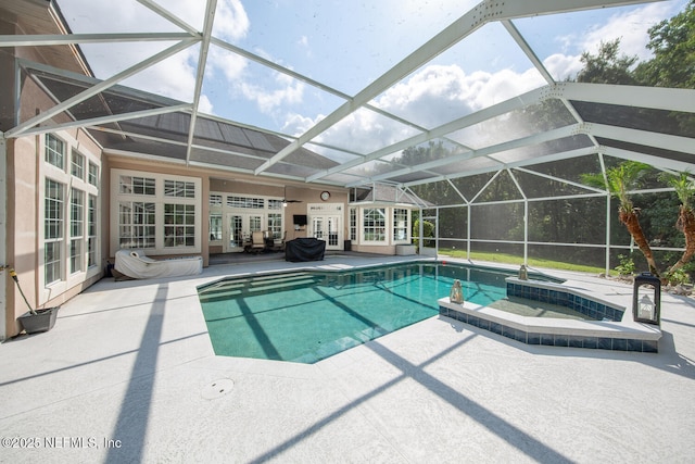 pool featuring a lanai, a patio, french doors, and an in ground hot tub