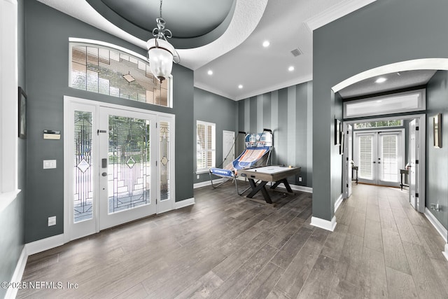 foyer entrance with visible vents, baseboards, wood finished floors, and french doors