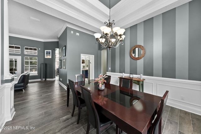 dining room featuring a decorative wall, a wainscoted wall, a notable chandelier, ornamental molding, and dark wood finished floors