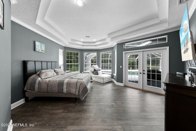 bedroom with access to outside, a raised ceiling, dark wood finished floors, and french doors