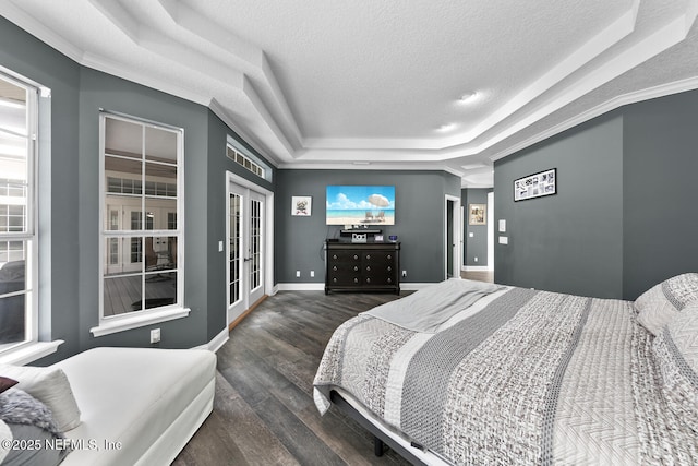 bedroom featuring baseboards, dark wood finished floors, a tray ceiling, a textured ceiling, and french doors