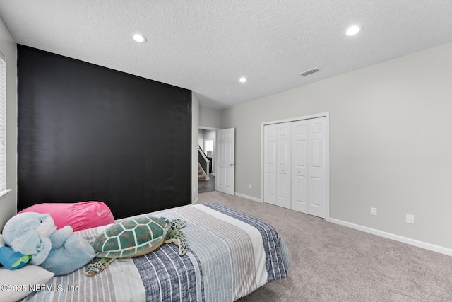 bedroom with carpet, recessed lighting, a closet, a textured ceiling, and baseboards