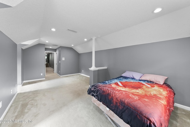 bedroom with a textured ceiling, carpet flooring, visible vents, baseboards, and vaulted ceiling