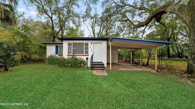 view of outdoor structure featuring driveway, fence, an attached carport, and entry steps