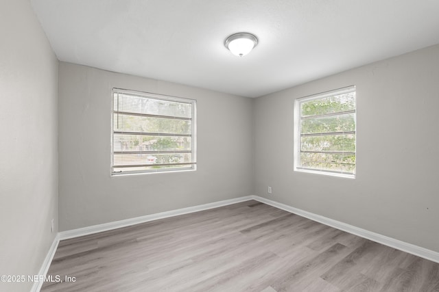 unfurnished room featuring light wood-style flooring and baseboards