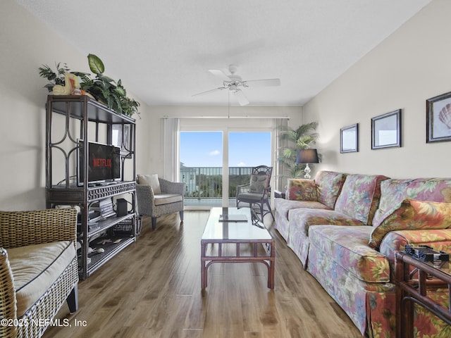 living room with ceiling fan and wood finished floors
