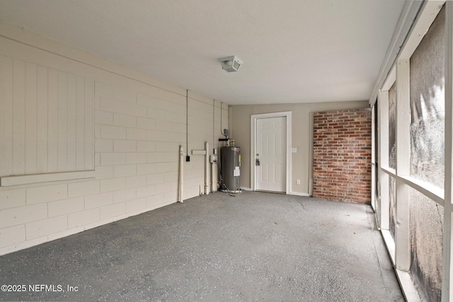 garage featuring concrete block wall and water heater