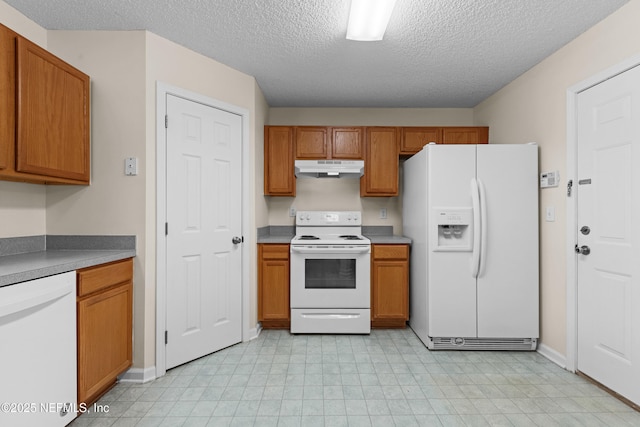 kitchen with white appliances, brown cabinets, under cabinet range hood, and a textured ceiling