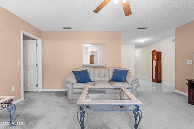 living area with carpet floors, visible vents, and a textured ceiling