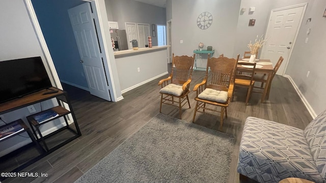 dining area featuring dark wood-type flooring and baseboards