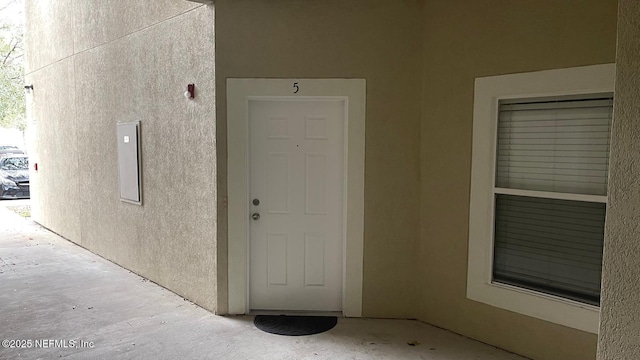 view of exterior entry with stucco siding