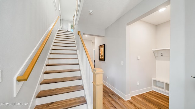 staircase with wood finished floors and baseboards