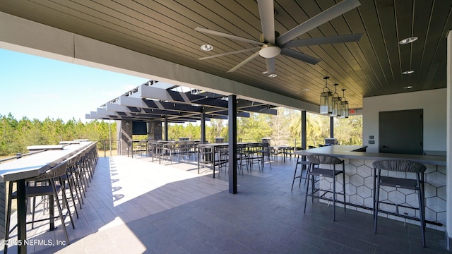 view of patio / terrace featuring a ceiling fan and a bar