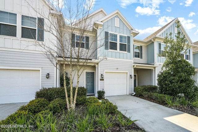 townhome / multi-family property featuring board and batten siding, driveway, and a garage