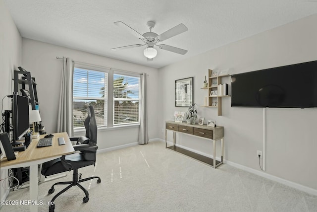 carpeted home office featuring a textured ceiling, a ceiling fan, and baseboards