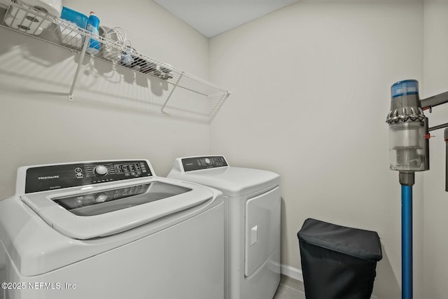 washroom with laundry area, baseboards, and washer and clothes dryer