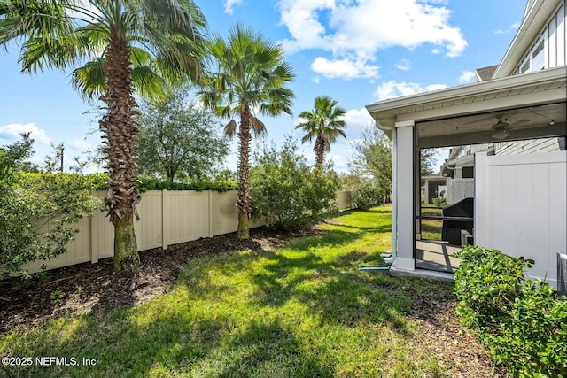 view of yard with a fenced backyard and a ceiling fan