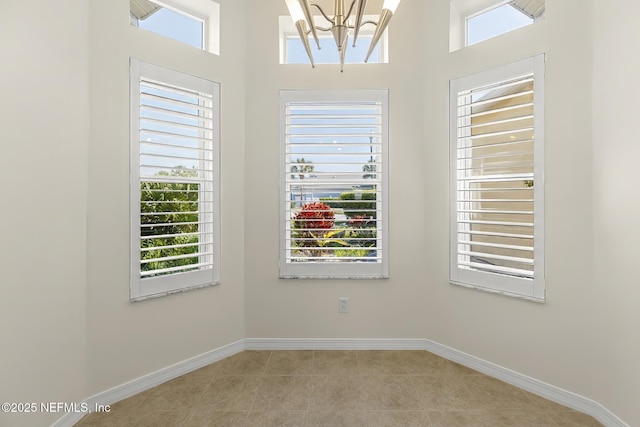 180 Kingston Dr, Saint Augustine, FL 32084 - empty room with light tile patterned floors, baseboards, and a chandelier