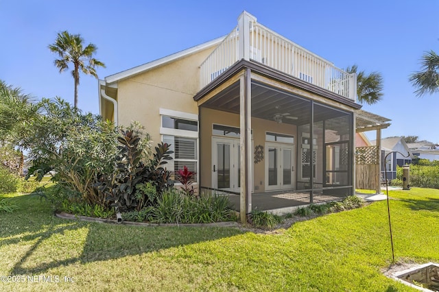180 Kingston Dr, Saint Augustine, FL 32084 - rear view of property featuring stucco siding, a ceiling fan, a lawn, a balcony, and french doors