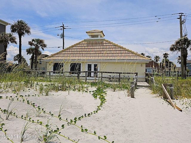 180 Kingston Dr, Saint Augustine, FL 32084 - back of house with stucco siding, a tiled roof, and fence