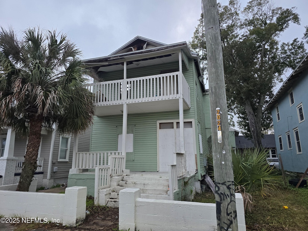 multi unit property featuring covered porch and a balcony