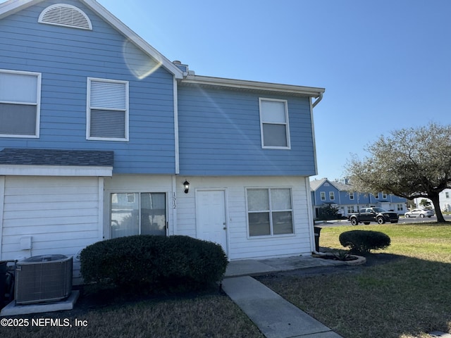 townhome / multi-family property featuring a front lawn and central AC unit