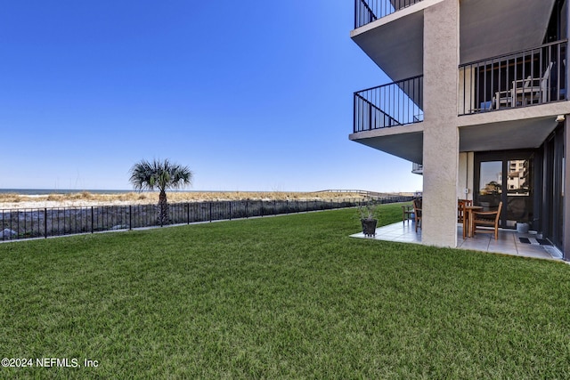 view of yard with a balcony, a patio area, and fence