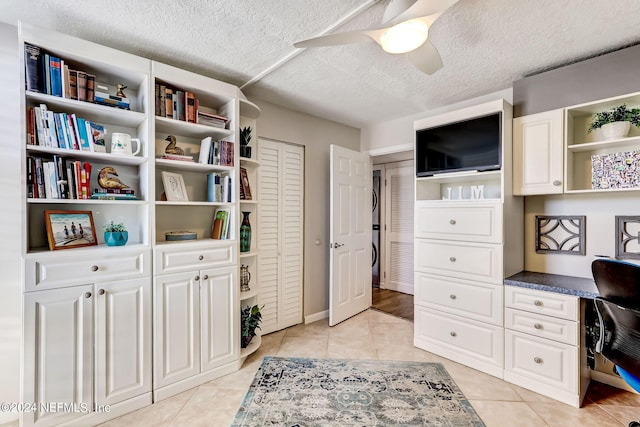 home office featuring light tile patterned floors, ceiling fan, a textured ceiling, and built in desk