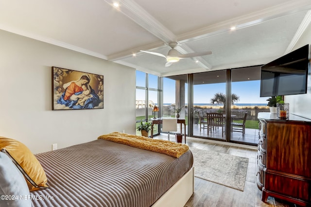 bedroom with light wood finished floors, access to exterior, a wall of windows, multiple windows, and beam ceiling