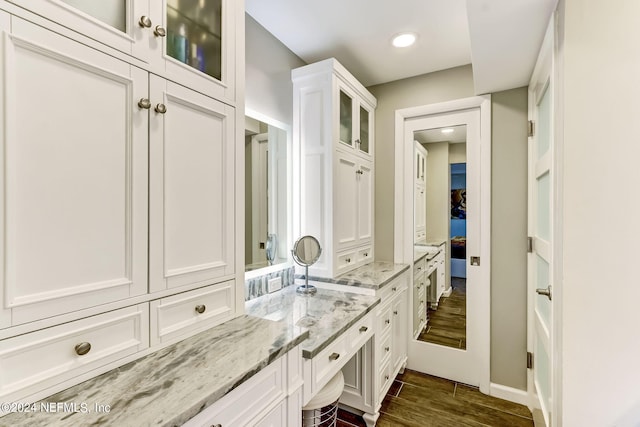 ensuite bathroom featuring ensuite bathroom, wood finished floors, and vanity