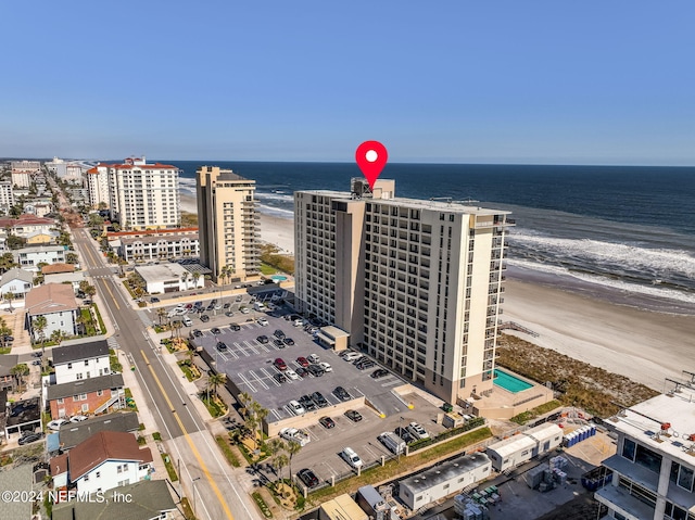 drone / aerial view featuring a view of city, a water view, and a view of the beach