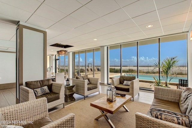 living room featuring recessed lighting, floor to ceiling windows, baseboards, and wood finished floors