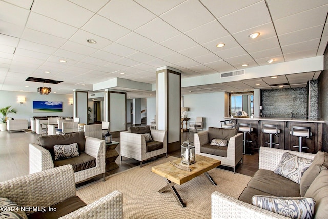 living room with ornate columns, visible vents, wood finished floors, and recessed lighting