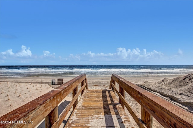 view of property's community featuring a water view and a beach view