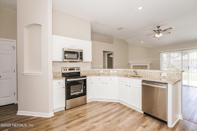 kitchen featuring stainless steel appliances, white cabinets, and a peninsula