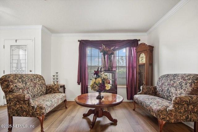 sitting room featuring ornamental molding and wood finished floors