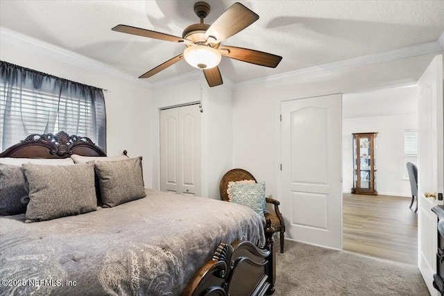 bedroom featuring a textured ceiling, ornamental molding, a closet, and carpet