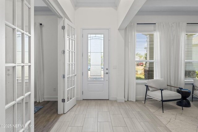 foyer entrance featuring baseboards, french doors, and crown molding